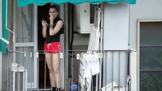 Nice teen enjoying the call on the balcony