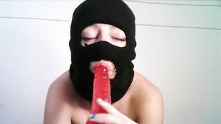 Masked teen giving a blowjob to a dildo