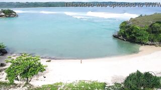 Putri Cinta stripping on a beautiful tropical beach