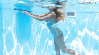 Her body cutting through the shimmering water of the pool