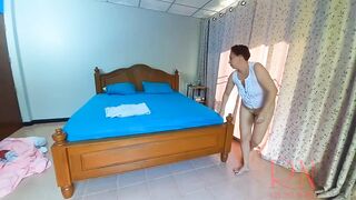 Nudist housekeeper Regina Noir makes the bedding in the bedroom. Naked maid. Naked housewife. c2