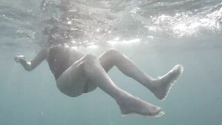 Swimming and peeping on Acquatica, dressed in a black one-piece swimsuit, spyng on legs and feet