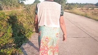 Auntie walks and shows off her breasts on the side of the road.