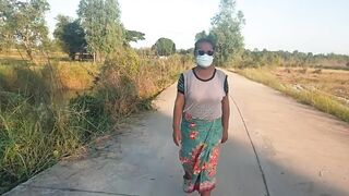 Auntie walks and shows off her breasts on the side of the road.